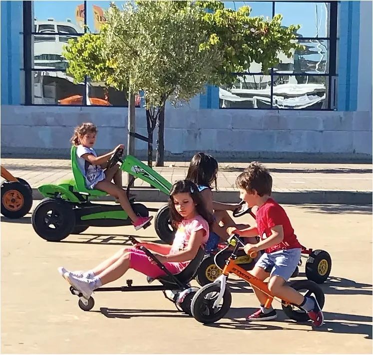 Grupo de crianças em karts e trikes a pedal junto ao Museu do Oriente