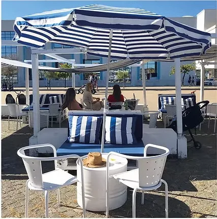 Esplanada da Fun Track com chapéus de sol às riscas e sofás lounge