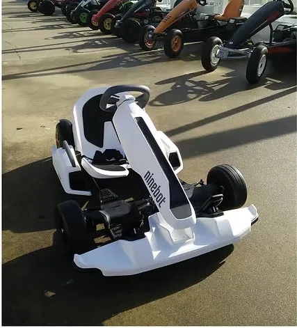 Kart eléctrico branco estacionado à frente da fila de karts a pedal
